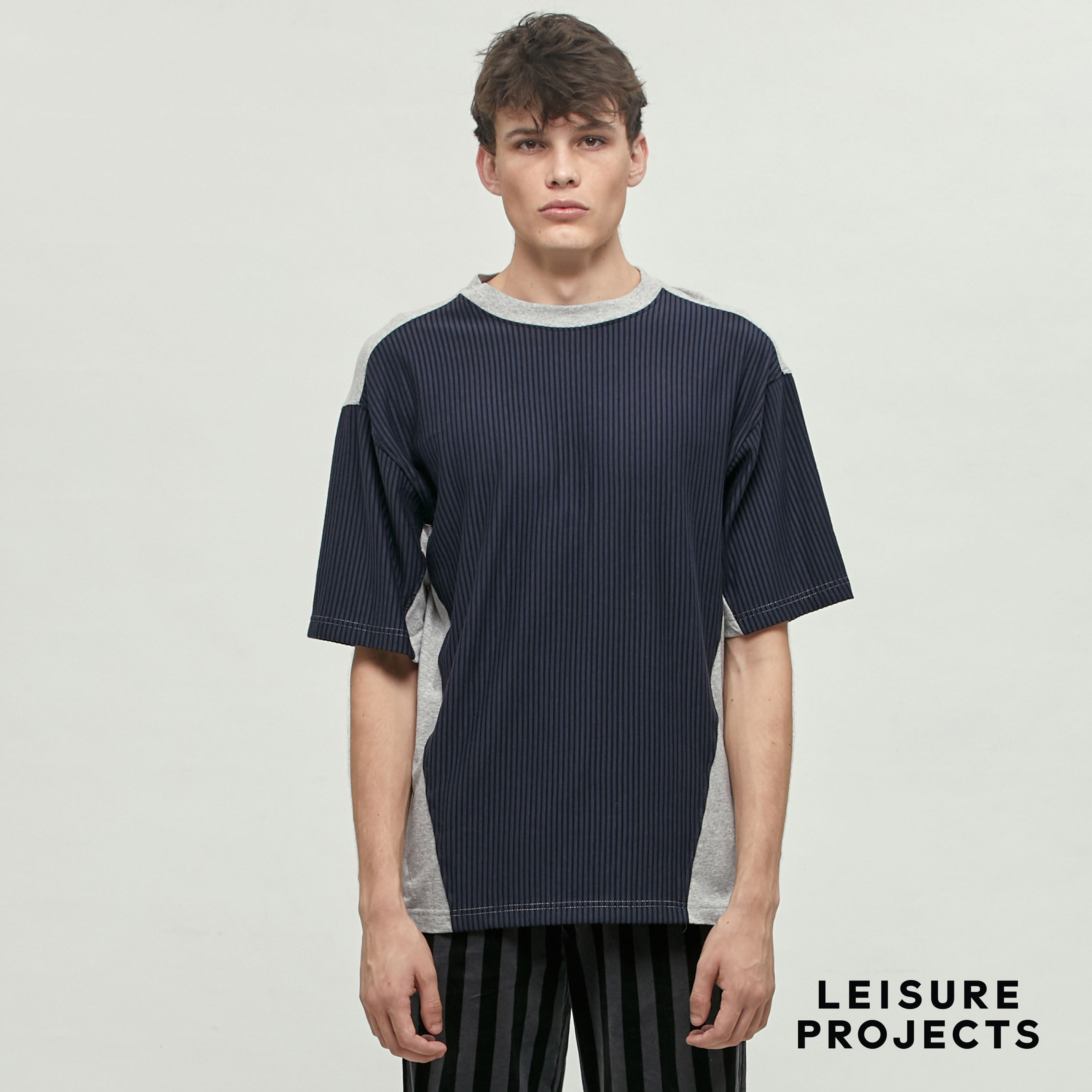 (LEISURE PROJECTS) PANEL T-SHIRT เสื้อยืด คอกลม ทรง oversize LEISURE PROJECTS ดีเทลตัดต่อผ้าลายทางด้านหน้า